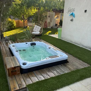 Paysage Marc : Aménagement du contour d'un spa avec du gazon synthétique.