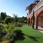 maison rose et jardin verte avec des plantes